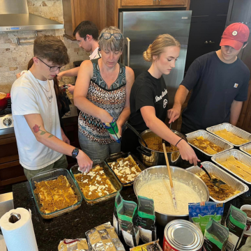 Volunteers cooking lasagna together