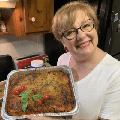 Volunteer with three cooked lasagnas